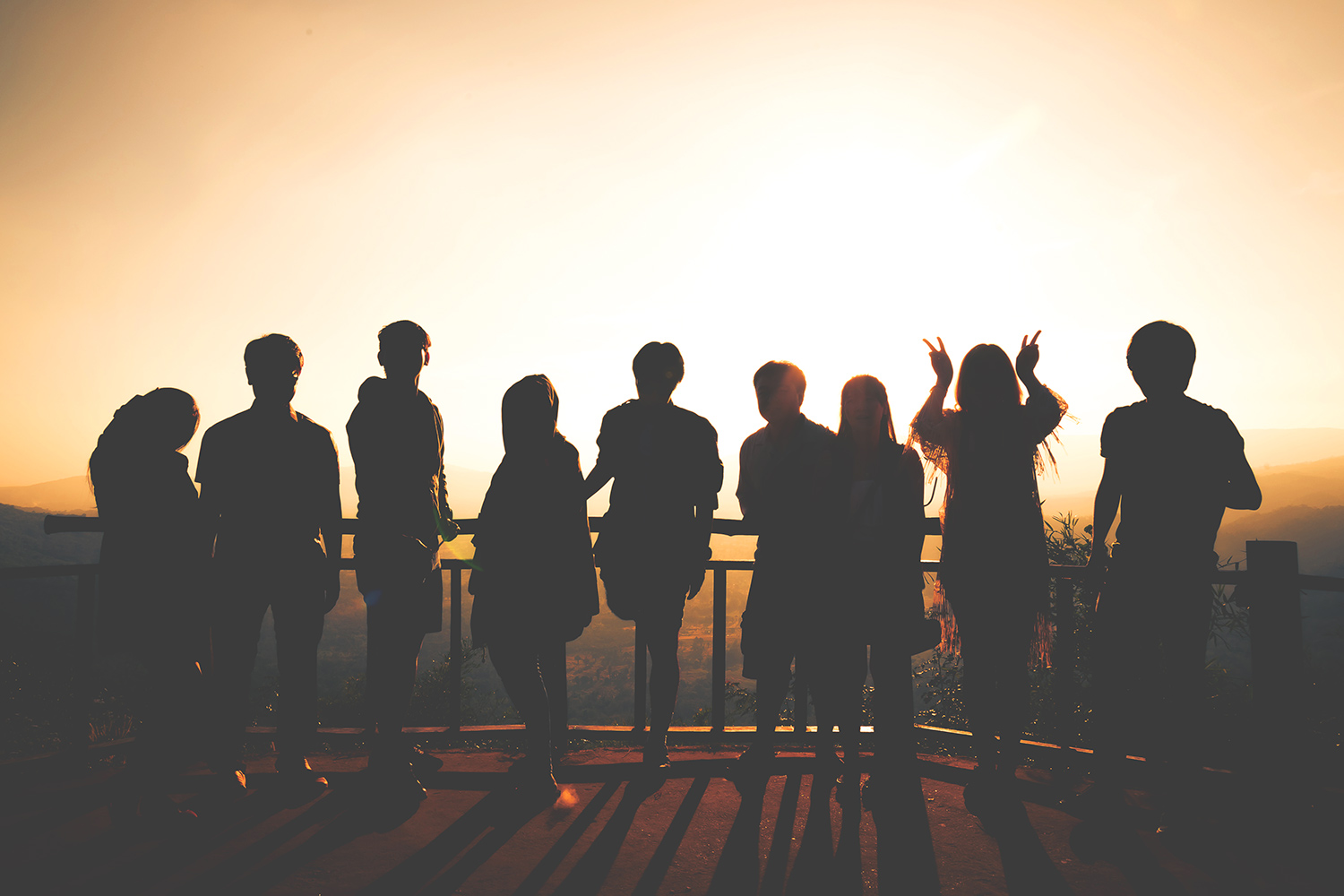 Silhouettes of young people against a sunset.