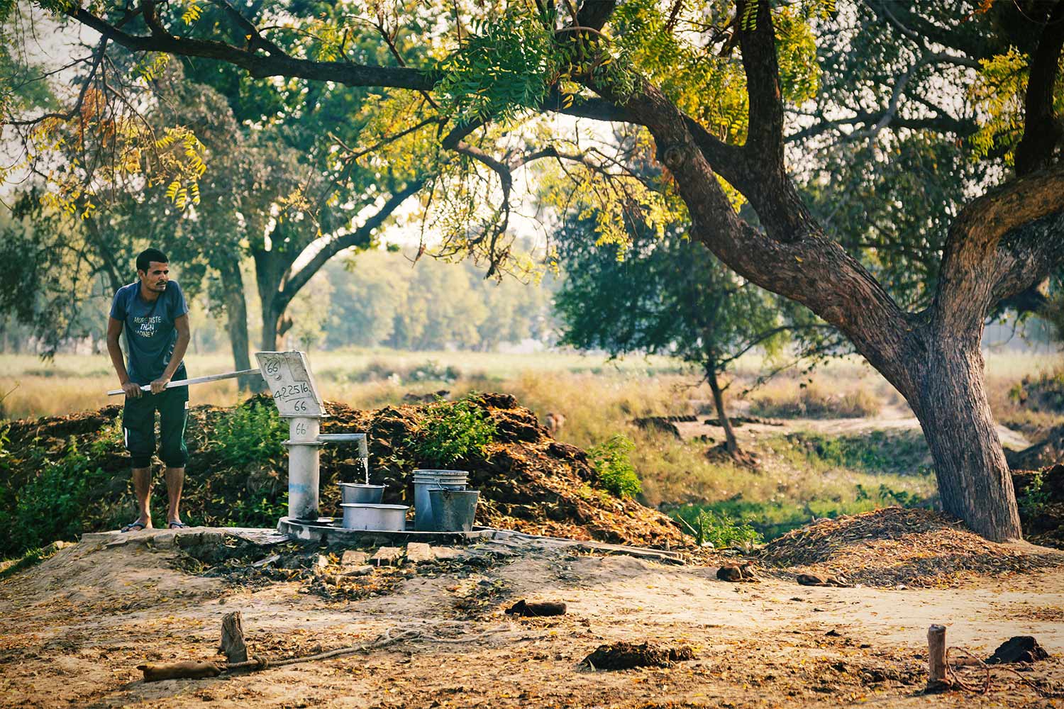 Man pumps groundwater from a communal village pump in Uttar Pradesh, India.