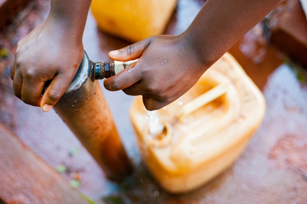 Filling up water tanks from a communal village tap.