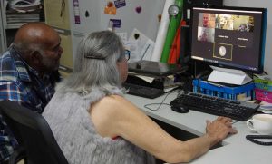 Woman and man looking onto a screen, e-meeting some people