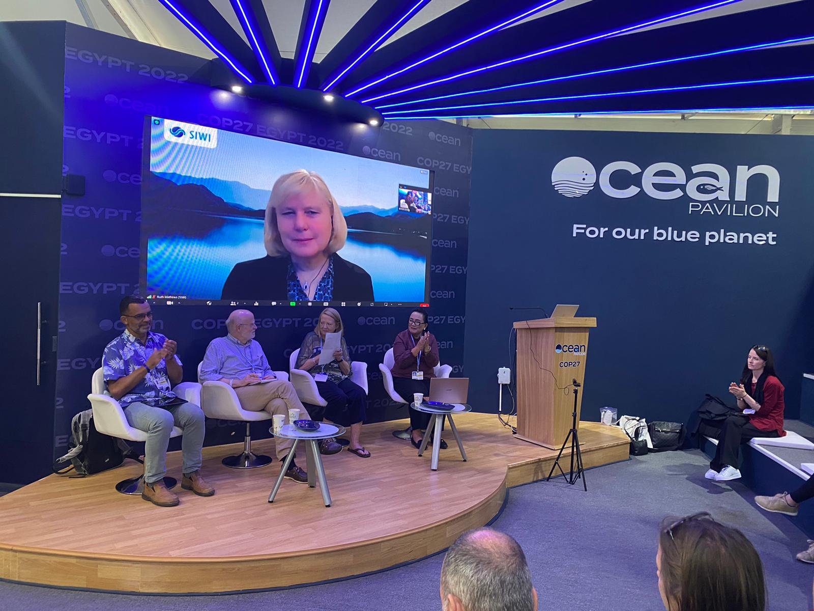 Ruth Matthews speaking on a screen at the Ocean Pavilion during COP 27