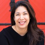 A woman smiling with a red background