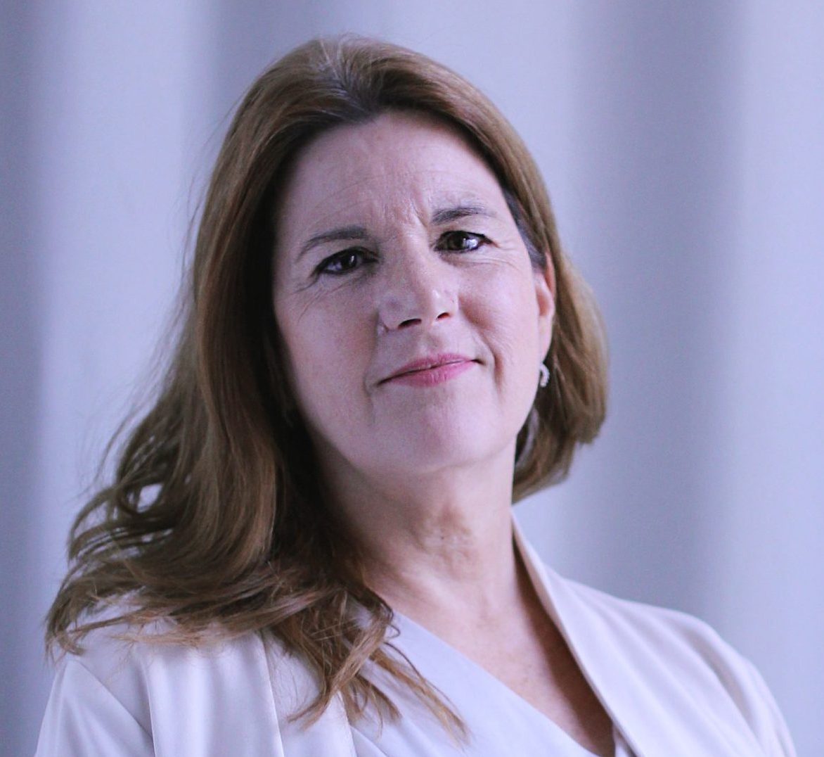 Person facing the camera wearing white blouse and soft blazer