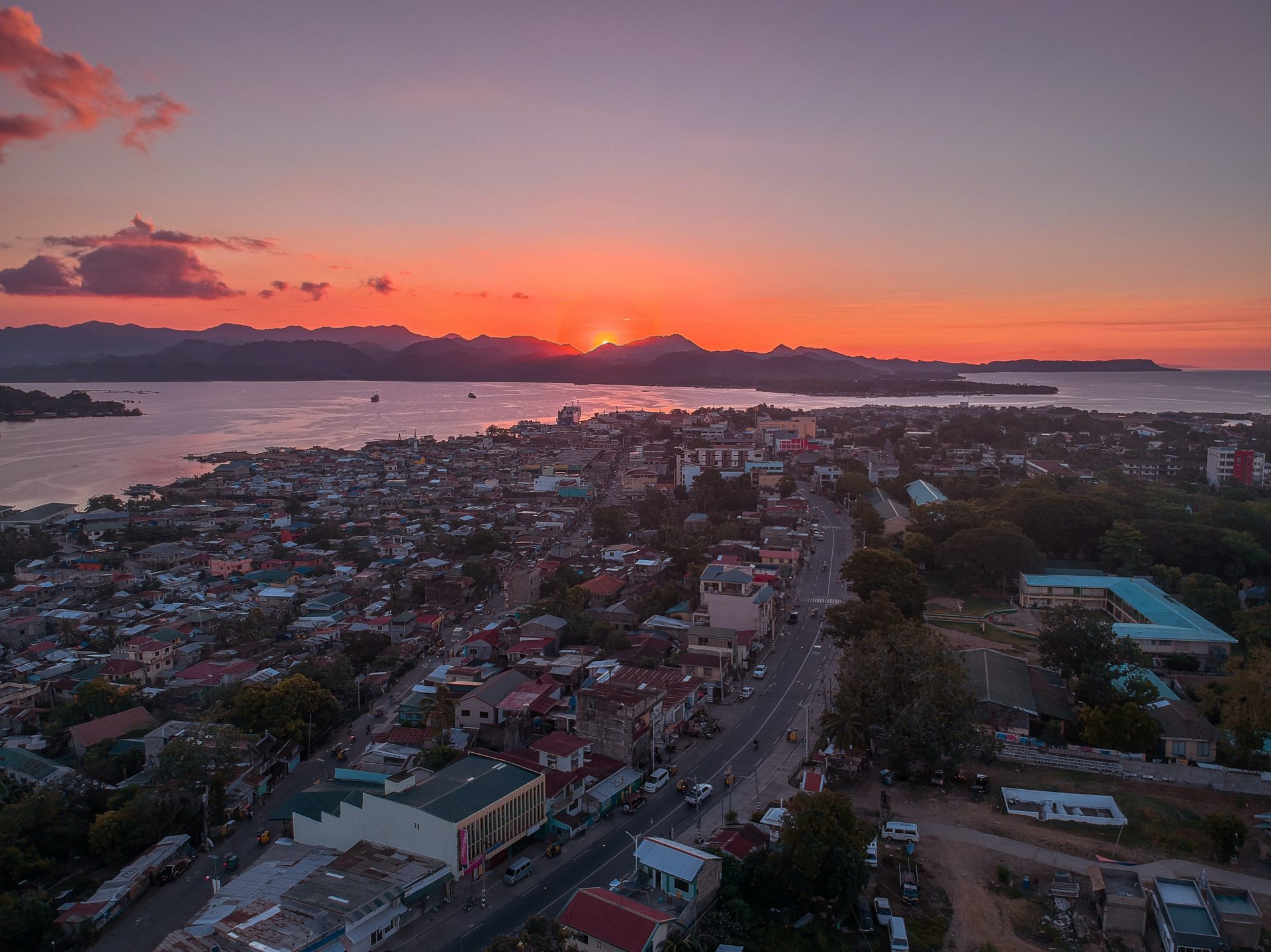 Skyview of a city at dawn, with river running in the background