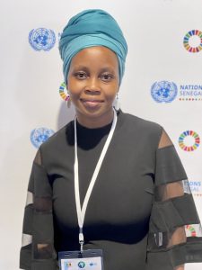 Woman in traditional headgear smiling at the camera