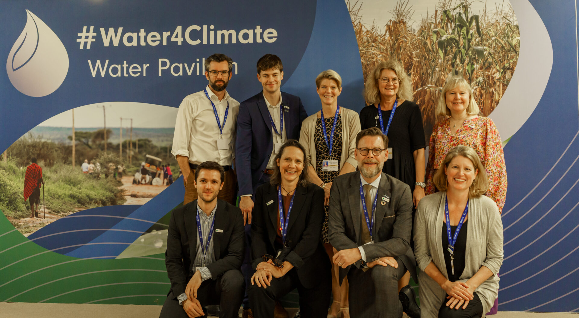 people standing in front of the COP28 backdrop