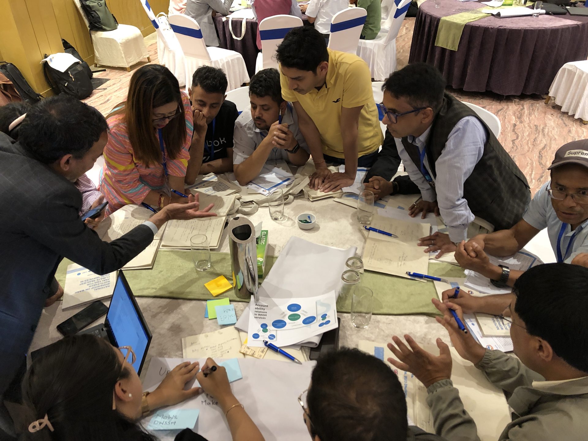 A group of people workshopping around a table