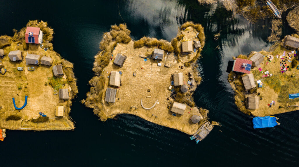 Aerial top view photo of floating islands on Lake Titicaca in Peru - a habitant of indigenous community Uros who are living on floating self-made islands made of totora plant